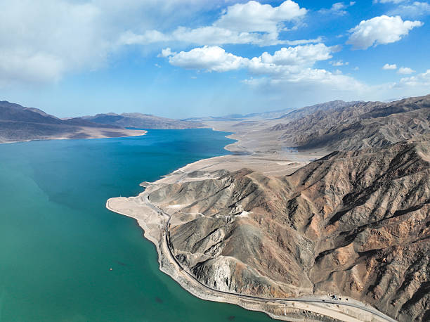 istock Turquoise reservoir shoreline and rugged mountains under a clear sky 2243028427