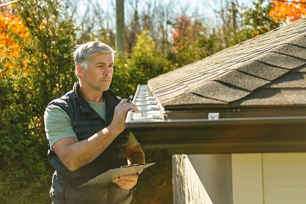 istock man standing on steps inspecting house roof 2243028660