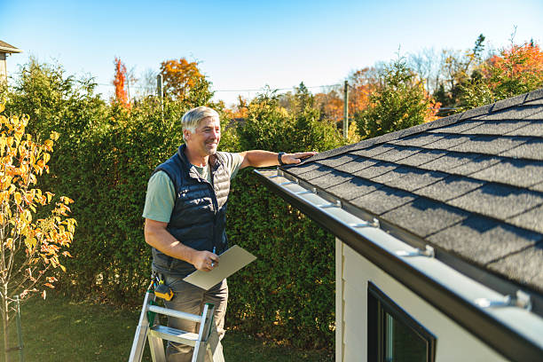 istock man standing on steps inspecting house roof 2243028671