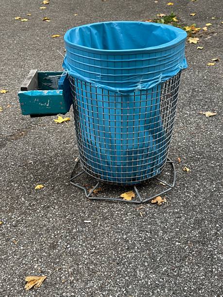 istock Blue trash can with a blue bag on top of it 2243029452