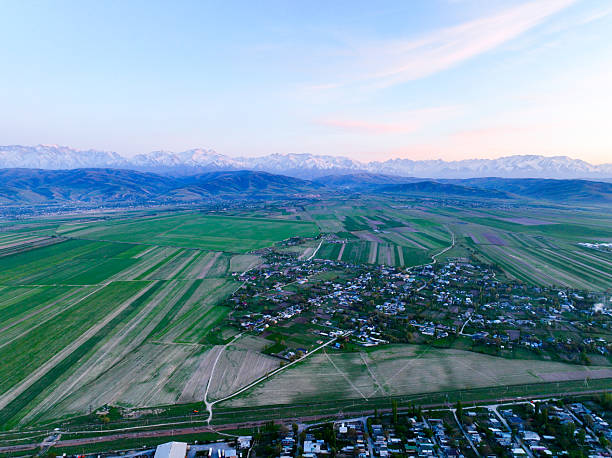 istock Vast agricultural fields and villages beneath a long mountain range at dusk 2243030536