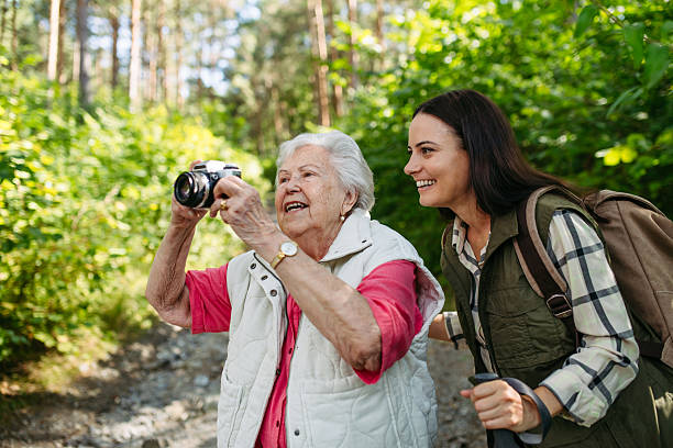 istock Elderly mother and daughter admire wildlife during forest walk. 2243035175