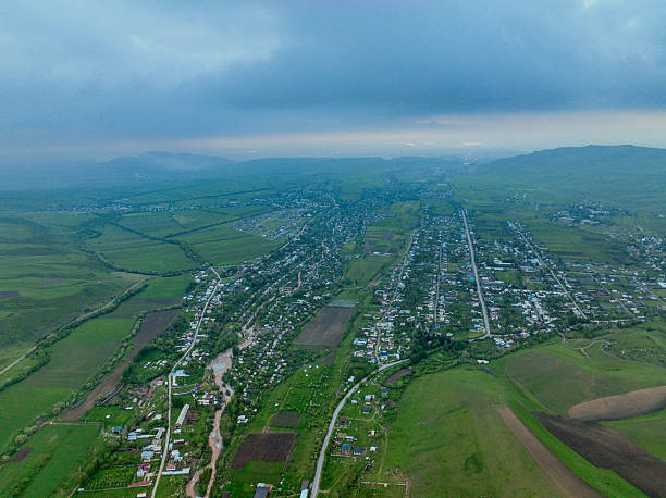 istock Expansive Village and Fields in Wide Green Valley 2243035463
