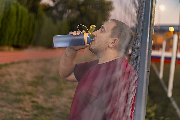 istock Oversize man stop to jogging to taking a rest and drinking water. 2243036335