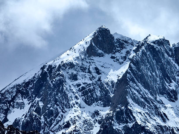 istock Snow-Covered Mountain Peak Against Moody Sky 2243038082