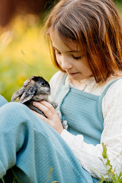 istock Young girl gently cuddles a fluffy bunny in her arms. 2243043319