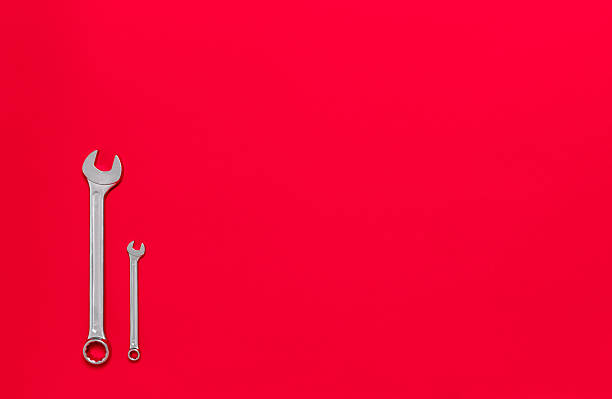 istock Two metal wrenches of different sizes isolated on a red background with copy space. Conceptual idea of the differences between: boss and employee, older and younger, big and small, parent and child 2243044255
