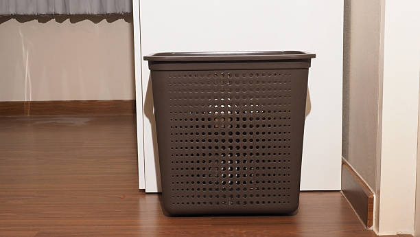 istock A brown plastic laundry basket stands on a wooden floor 2243056639