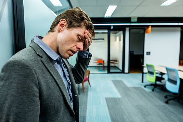 istock Stressed businessman with hand on forehead in modern office 2243065940