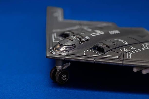 Top view of a B2 Spirit stealth bomber scale model displayed on a blue surface. The iconic flying wing design represents modern aviation, stealth technology
