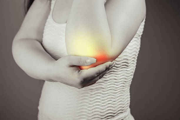 istock Woman suffering from pain in the elbow joint. Toned image. 2243081637