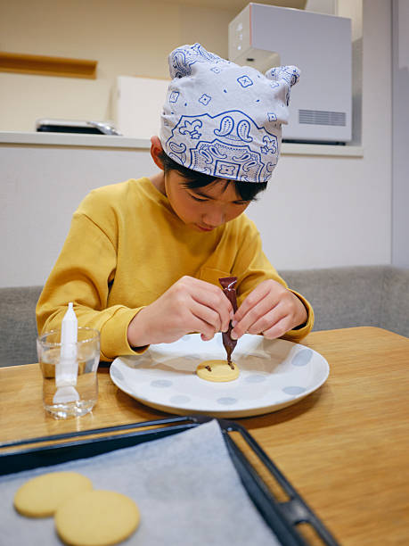 Young Boy Decorating Cookies in a Home