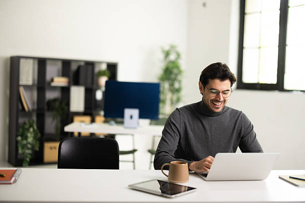 istock Man enjoying work on laptop in modern office 2243082726