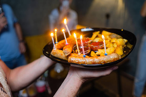 four people hold a hot dog together.