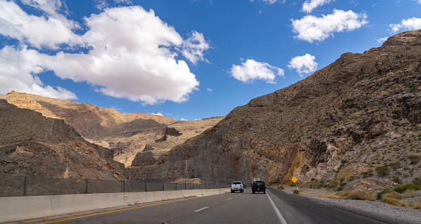 istock Vehicles drive on highway through rocky mountain pass. 2243086027