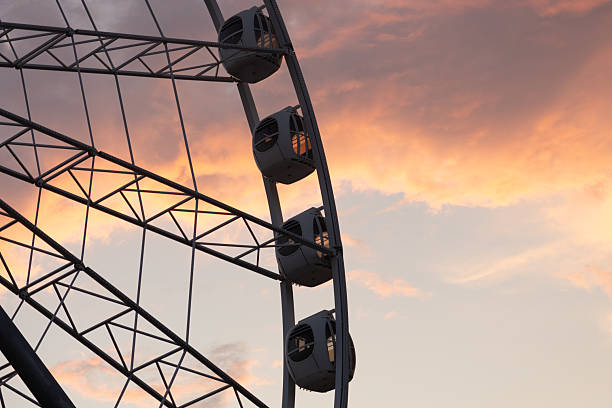 istock large Ferris wheel against a cloudy sky. The Ferris wheel is surrounded by sunset clouds. 2243086703