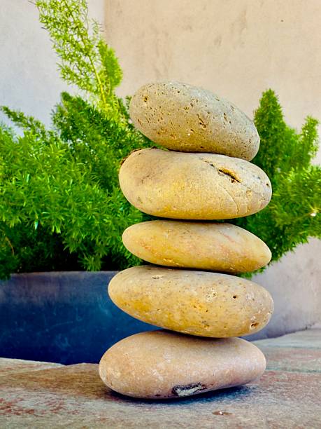 Round plate rocks are stacked on top of each other in a way that are not following down. Needed to find a good position for each rock so they can stay still (stocking) without crushing down. Got to find good balance. Located in Corona California.