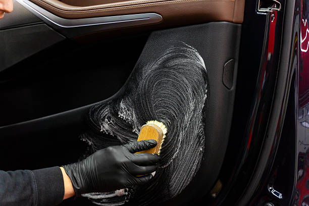 istock Deep cleaning car door panel with brush and chemical solution eliminates grime and debris. Door panel detailing removes dirt, dust, and stains from a car door panel using brush with detergent. 2243096042