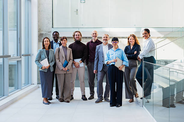 Diverse Team Of Professionals Standing Together In A Bright Modern Office Environment, Confident And Collaborative