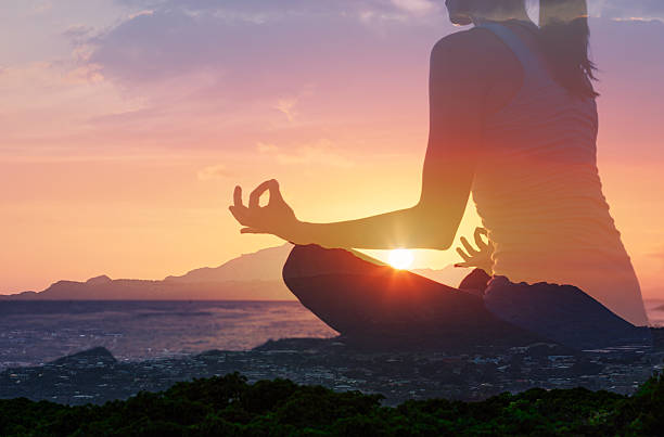 istock Woman peacefully meditating on the beach at sunset. 2243102230