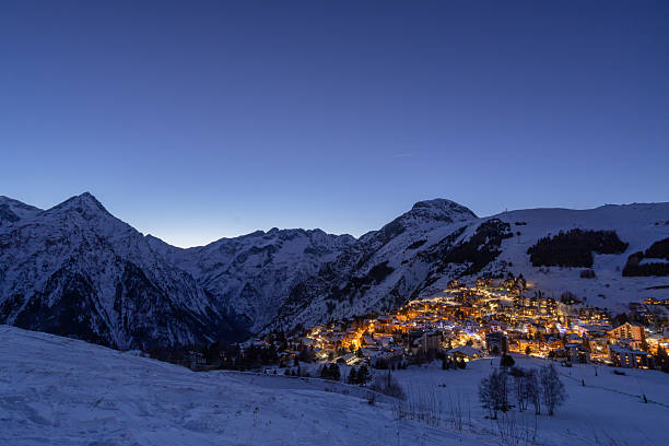 istock Twilight alpine village lights against snow-covered mountainside 2243102439
