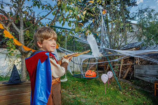 istock Little hero posing with wooden bow aiming festive decorations 2243103836