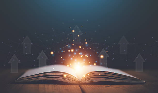 istock Old open book with mystic magic bright light on wooden table with arrow up on virtual screen, education, literature, religion topics. 2243108288