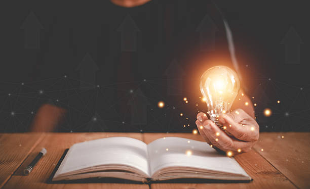 istock Hand holding light bulb on the open book, Thinking and creative concept, Knowledge and searching for new ideas, Education, Innovations, self-learning, Inspiring from read. 2243108295