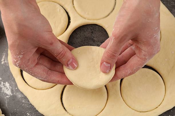 istock Woman making pirozhki (stuffed pastry pies) at gray table, top view 2243111223