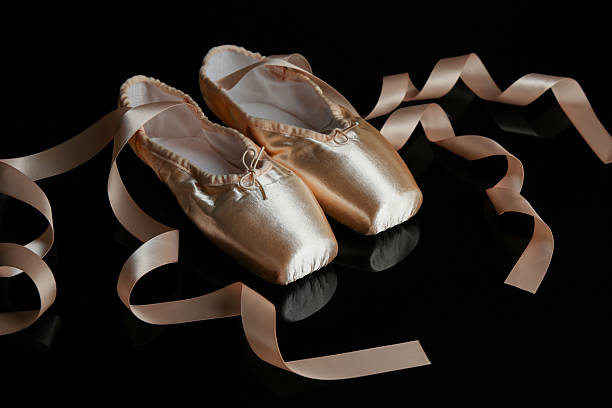 istock Pair of beautiful pointe shoes on black mirror surface 2243111383