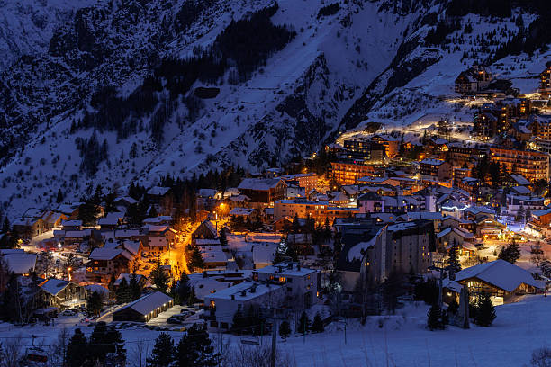 istock Snowbound resort village glows warmly under alpine night sky 2243111512