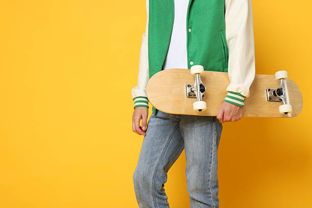 Man with skateboard on orange background, closeup. Space for text