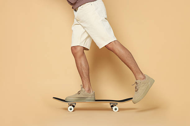 istock Man riding skateboard on beige background, closeup 2243111702