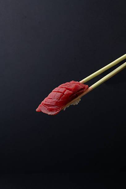 Tuna Nigiri Sushi Held by Chopsticks