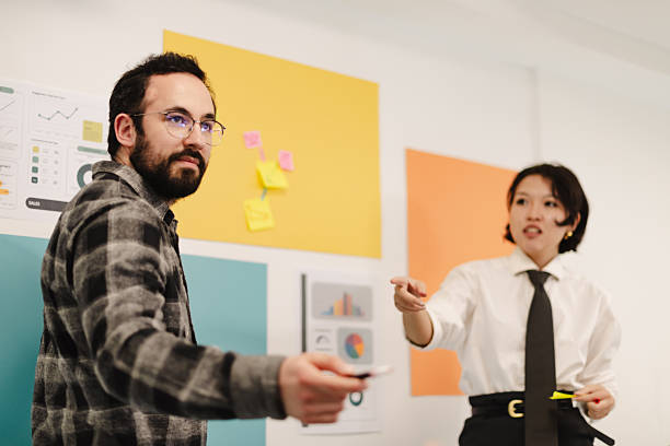 istock Business partners collaborate in a modern office space during a strategy meeting with colorful charts in the background 2243112113