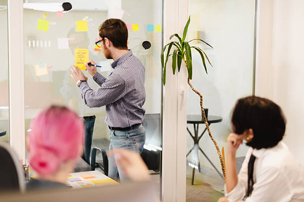 istock Business meeting featuring professionals brainstorming ideas in a modern office environment with sticky notes and collaborative tools 2243112128