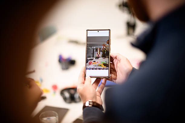 istock Group of people sharing memories through a smartphone in a bright indoor setting while enjoying a casual gathering with colorful decorations 2243112231