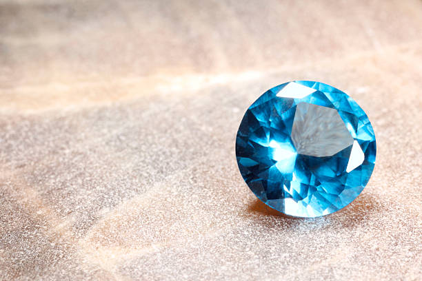 istock Beautiful shiny light blue gemstone on stone, space for text 2243112358