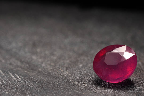 istock Beautiful shiny pink gemstone on stone, space for text 2243112365