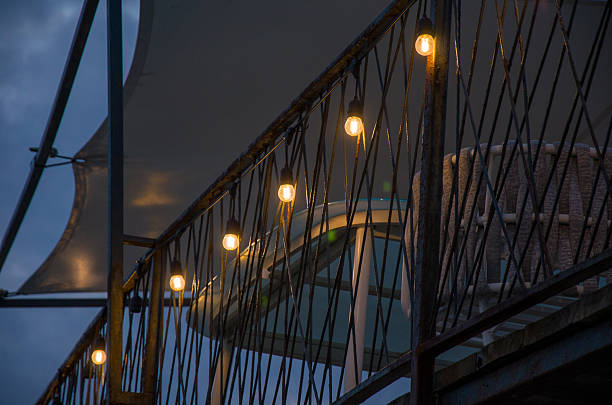 Cozy Balcony Ambiance String Lights on Rusty Metal Railing at Dusk