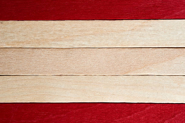This scene showcases wooden planks arranged in an alternating pattern of red and light wood. The smooth surface and vibrant colors offer a creative backdrop for various artistic projects.