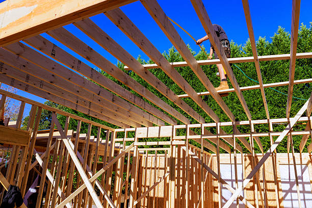 istock Construction worker installing roof beams in residential building 2243130074