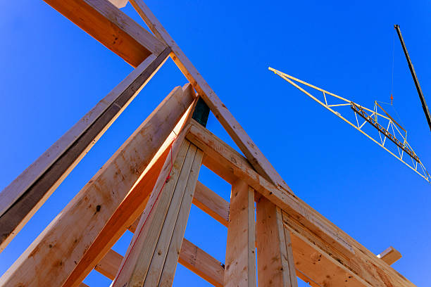 istock Construction project in progress with wooden frames crane against blue sky 2243130081