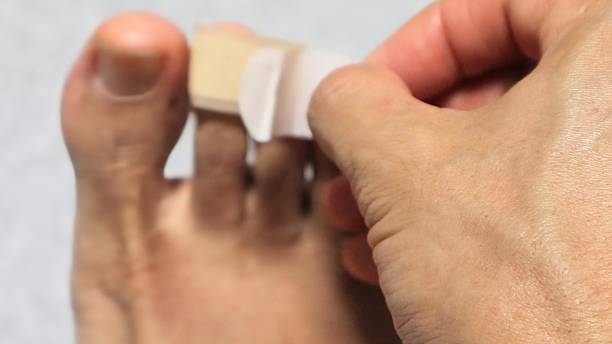 istock Person putting a bandage on his foot 2243135068