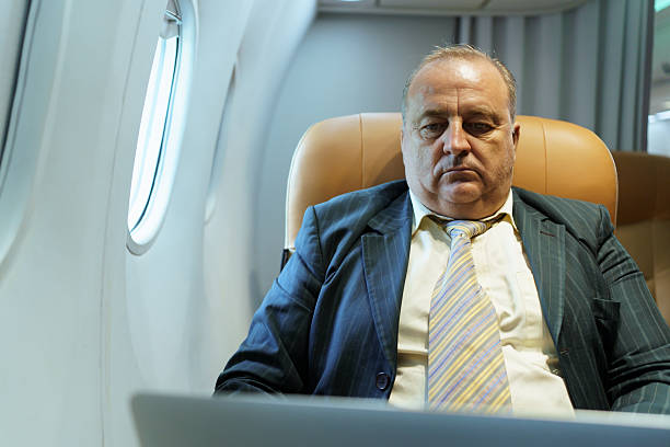 istock Businessman working on laptop in airplane business class during flight 2243141710