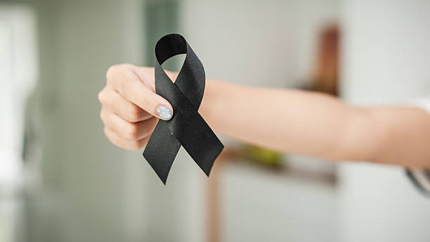 istock Funeral ribbon black held by hand indoor setting grief expression emotional space 2243153157