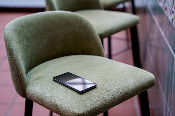 istock Smartphone left on chair at a bar counter 2243154493