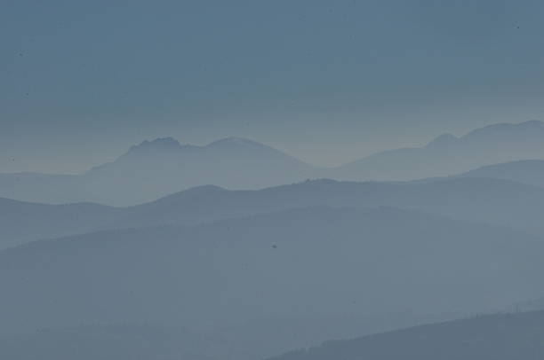 istock Distant mountain ranges shrouded in soft blue haze at dawn, creating a serene landscape 2243160443