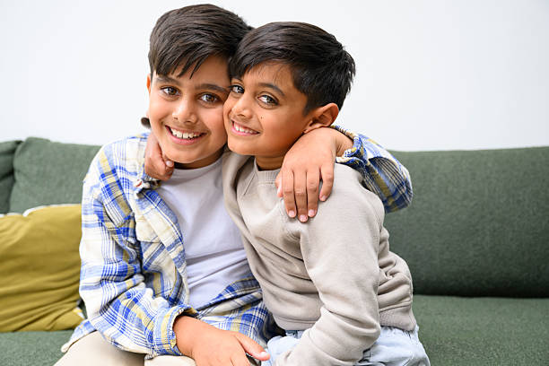 istock Two affectionate brothers hugging and smiling with arms around each other 2243163161