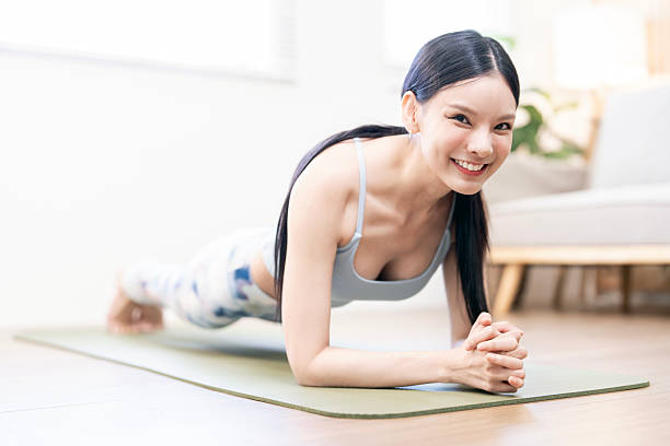 istock Smiling young woman holding a strong Forearm Plank (Dolphin Plank) pose during a home workout. 2243168631
